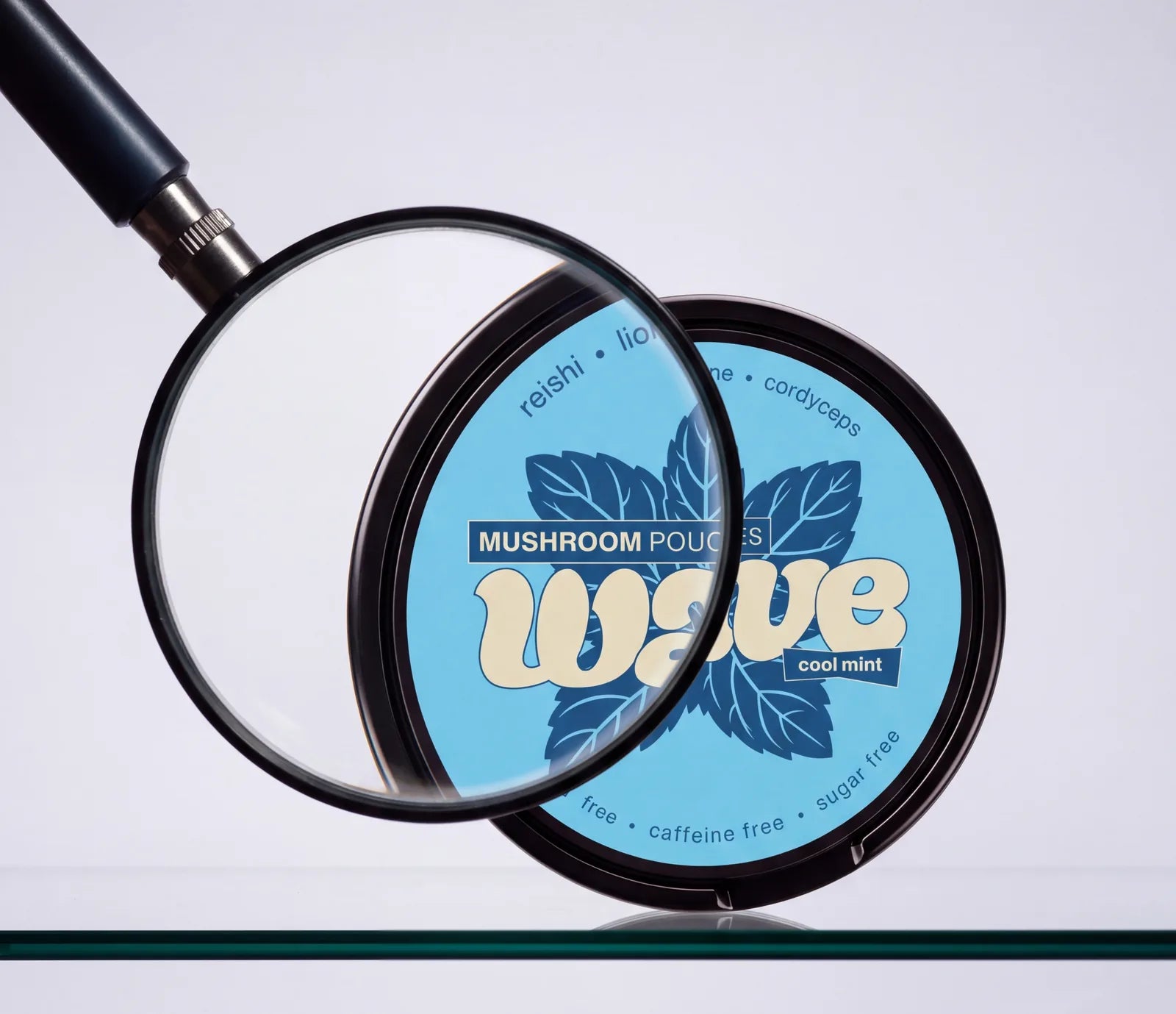 Une loupe au-dessus d’une boîte WAVE Cool Mint posée sur une étagère en verre